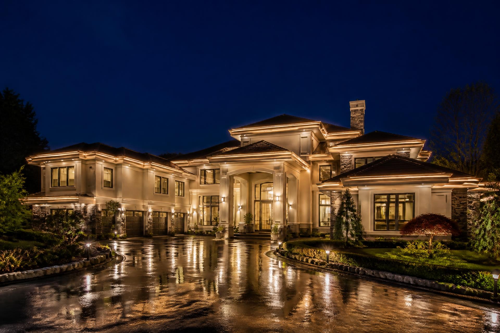 Luxury mansion at night with warm white permanent outdoor lighting outlining the roofline